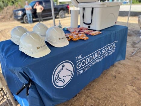 Goddard School groundbreaking day setup with hard hats